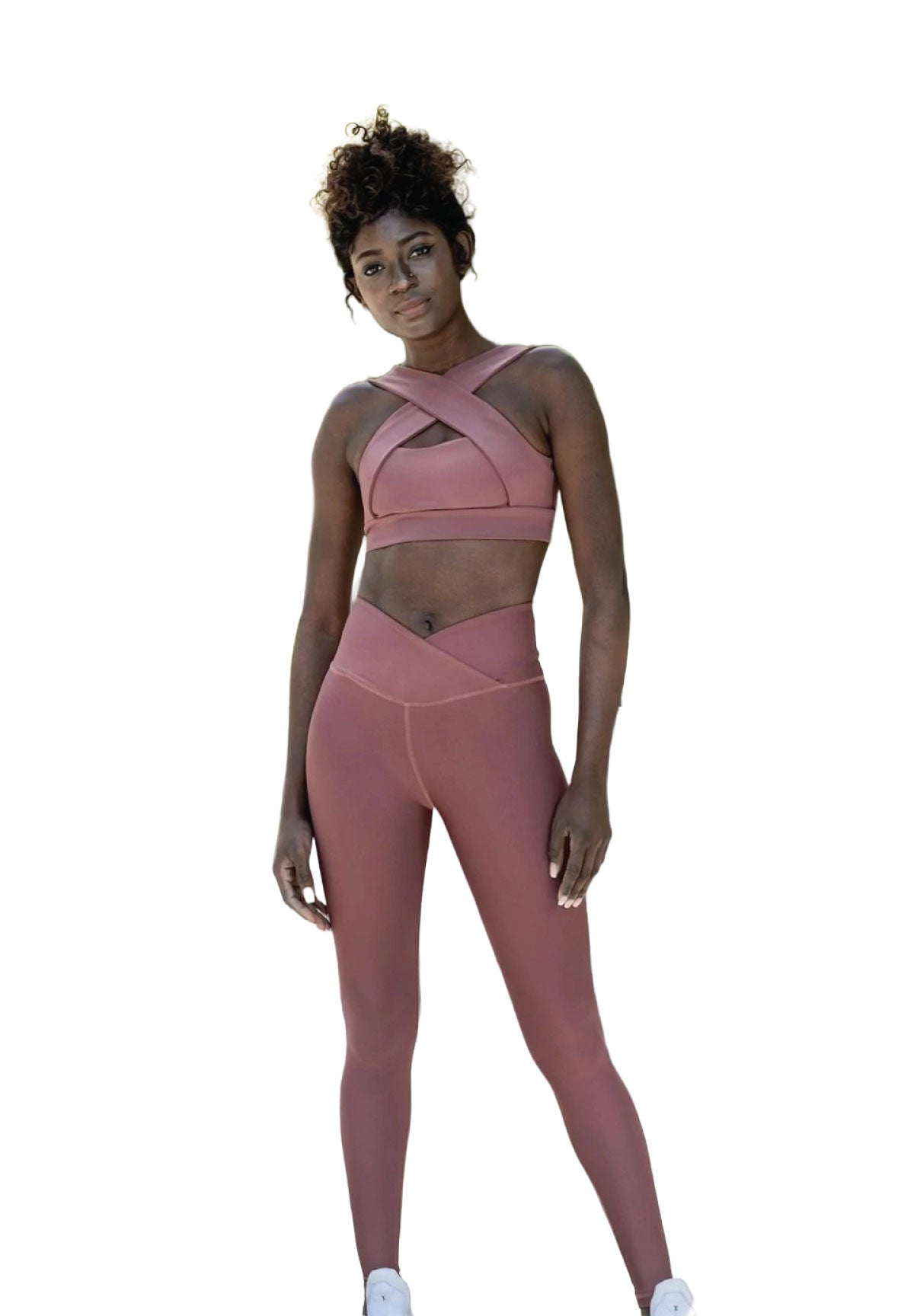 Person in Lisminas 1100 Ve Waist Leggings in Dunkelrosa und weißen Turnschuhen, bereit für Yoga vor einem weißen Hintergrund.